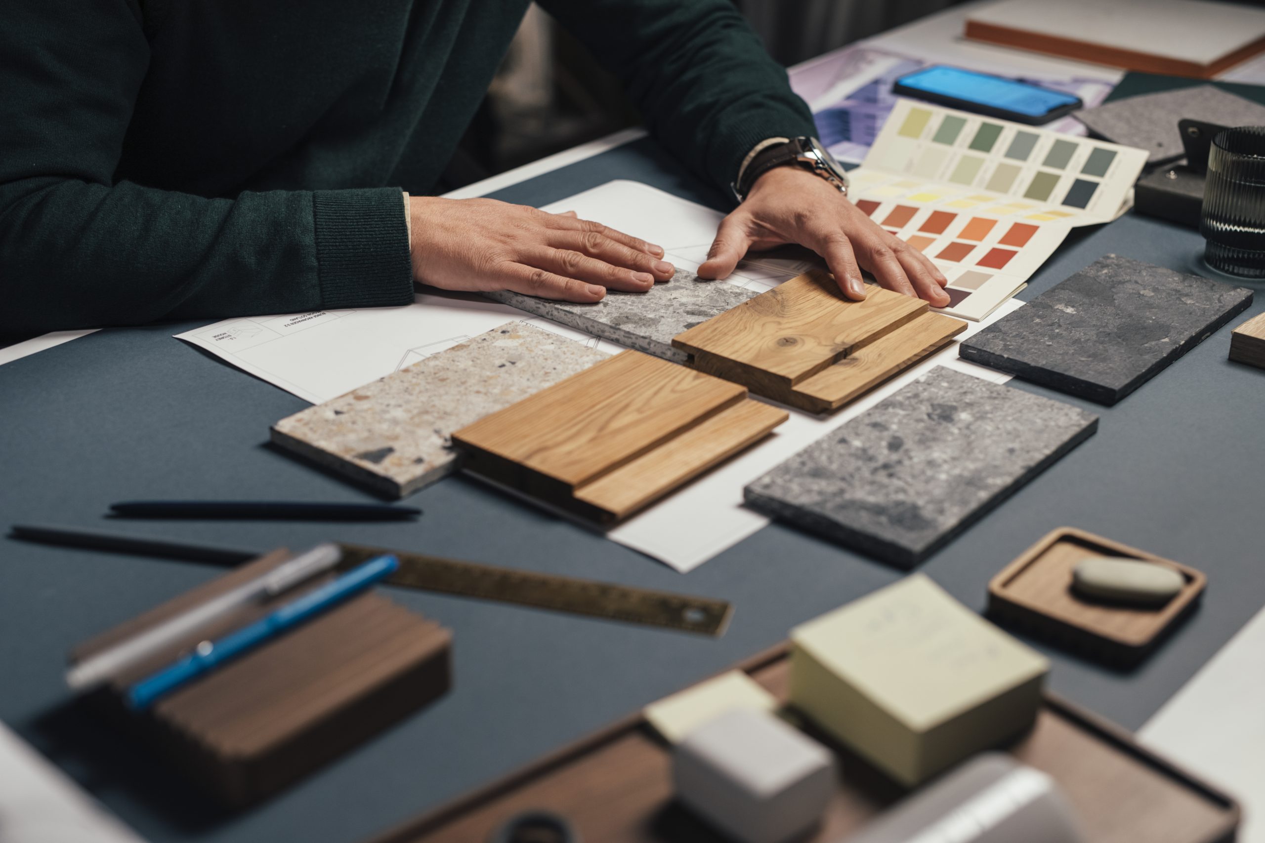 Hands Of An Anonymous Male Interior Designer Comparing Samples Of Different Materials In His Office